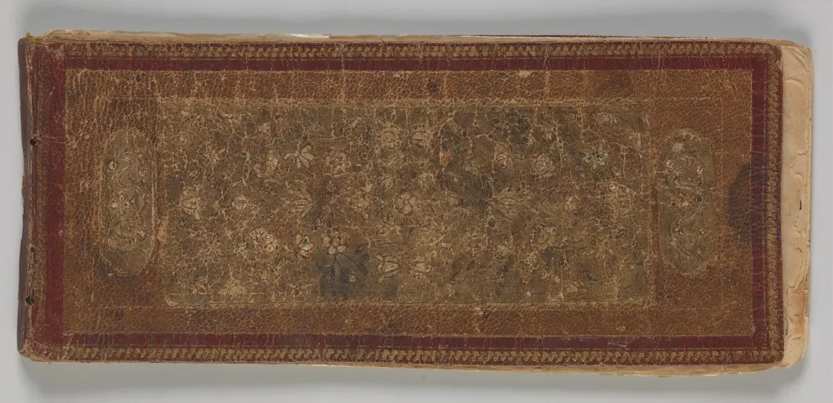 Open two-page spread of an oblong Persian poetry album in safina format with illuminated borders and diagonal nastaliq verses